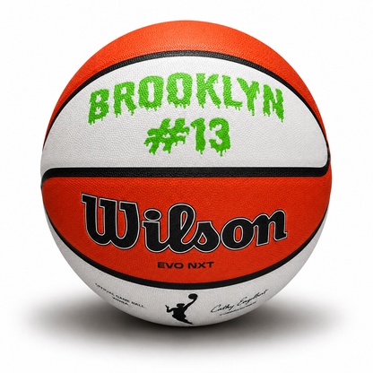 Customized WNBA Official Game Basketball with custom text written on the top panel in bright green color.